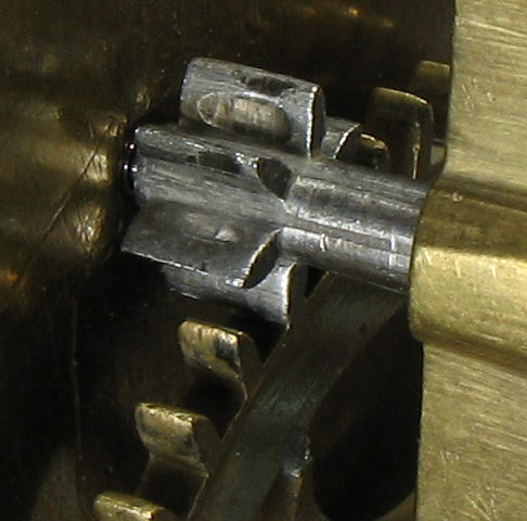 Gears with wear in a longcase clock by John Draper of London, c. 1705 (British Museum No. 1959,0202.1).  The pit that can be seen in the flank of the pinion tooth was caused by the tips of the teeth of the wheel which drive it.