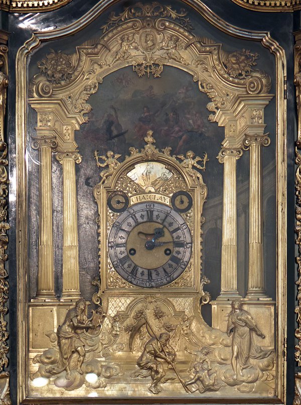 Close-up of the Clay clock. In the painted and cast bronze relief below we see Father Time, with hourglass and scythe, overcome by the power of music, which is represented by Apollo with his lyre and a woman personifying music